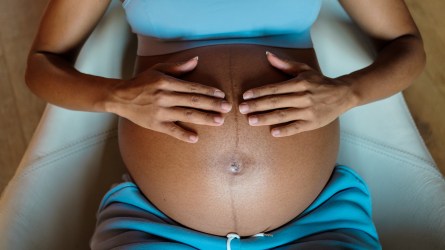 A pregnant woman touching her belly.