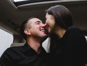 Man and woman kissing in car