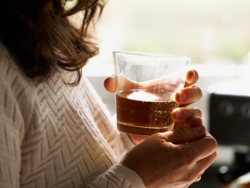 Woman holding a cocktail in a glass.