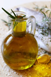 Fresh fish and olive oil in the bottle with herbs and mediterranean spices