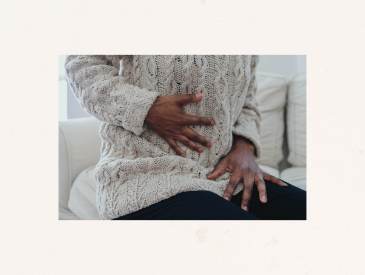 Woman holding stomach, experiencing pelvic pain.