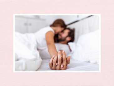 Couple in bed holding hands