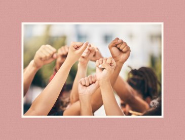 Young women raising their firsts in the air.