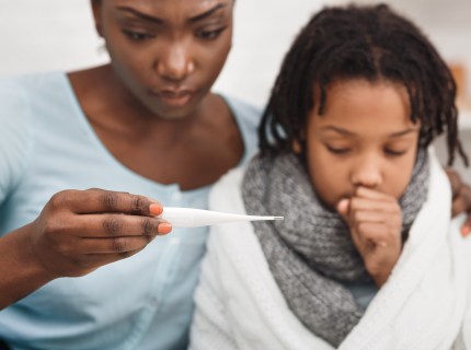 Cold Symptoms. Worried mother looking at thermometer, ill daughter coughing.