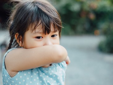 Child coughing into elbow