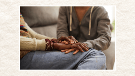 Women holding hands on a couch