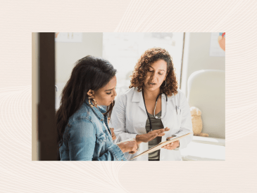 A female doctor discusses a young patient's diagnosis with the patient's mother. They are reviewing the patient's test results.