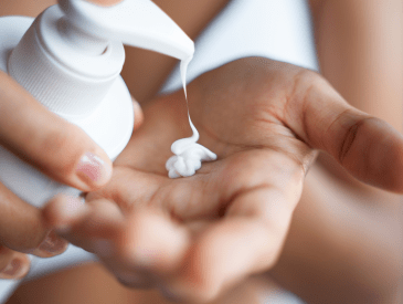 woman using lightweight hand lotion like Pixi's HandHero Purifying Lotion